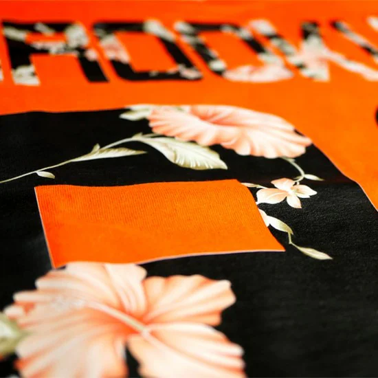 strygestof af høj kvalitet, Siser® Colorprint® Nærbillede af sort stof med blomstermønster og orange bogstaver